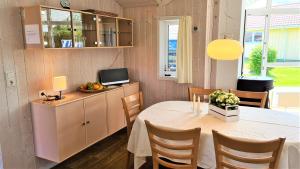 een eetkamer met een tafel en een tv bij Ferienhaus Strandoase in Brodersby