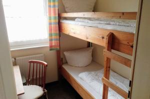 un par de literas en una habitación con silla en Ferienwohnung Einfach Urlaub Nr 2, en Maasholm