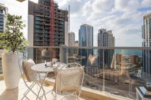 a table and chairs on a balcony with a view of a city at Frank Porter - Marina Tower in Dubai