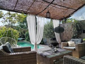 un patio al aire libre con piscina, mesa y sillas en Chambre d'hôtes Les Magnolias, en Pontpierre