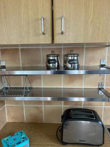 a kitchen with two pots and a toaster on a shelf at 1BDR Apartment-Aglantzia in Aglantzia