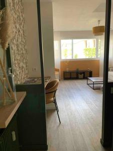 a living room with a couch and a table at Charmant studio cosy avec parking in Caen +8 photos