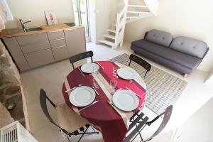 una mesa roja con sillas y un sofá en una habitación en Ker Bara en La Trinité-sur-Mer