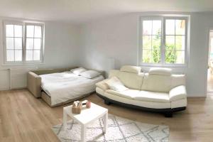uma sala de estar com um sofá e uma cama em Gîte Niederbronn-les-Bains em Niederbronn-les-Bains