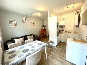 uma pequena sala de estar com uma mesa e uma cozinha em L’azur - Centre ville & Lac em Nantua