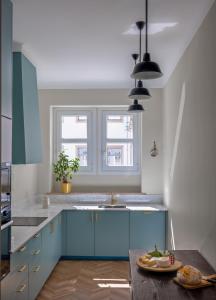 una cocina con armarios azules y fregadero en Casa dos Correios, en Vila Real