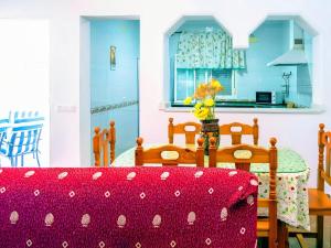 una cucina con tavolo e tovaglia rossa di Chalet Piscina Privada Zona Vallada con Barbacoa a Conil de la Frontera