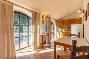 een keuken met een tafel en een groot raam bij Canaiolo in Montepulciano