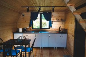 a kitchen with a table and a dining room at Vaso-Levani Kazbegi Cottage in Kazbegi