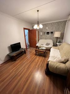 a living room with a couch and a television at Meszlényi Apartman II in Pécs