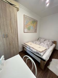 una piccola camera con un letto e una mappa sul muro di Meszlényi Apartman II a Pécs