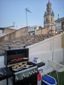 a bbq grill on a rooftop with a clock tower at La Casa del Chellero in Enguera