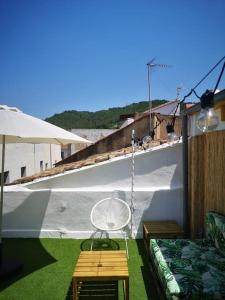 a patio with a swing and a chair and an umbrella at La Casa del Chellero in Enguera