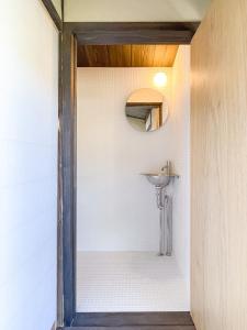 ein Bad mit einem Waschbecken und einem Spiegel in der Unterkunft Akizuki Kayabuki Kominka in Asakura