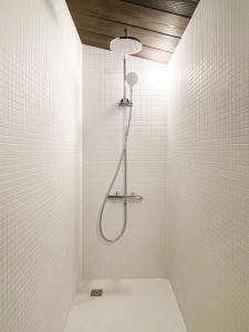 een badkamer met een douche in een witte muur bij Akizuki Kayabuki Kominka in Asakura
