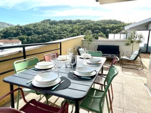 une table bleue avec des chaises et des assiettes sur un balcon dans l'établissement L’attique - Standing et Terrasse au centre-ville, à Bellegarde-sur-Valserine