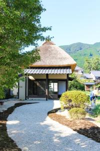 een tuinhuisje met een rieten dak en een wandelpad bij Akizuki Kayabuki Kominka in Asakura