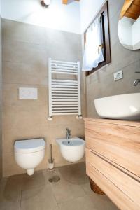 y baño con aseo blanco y lavamanos. en G&B suite en Castelnuovo di Porto