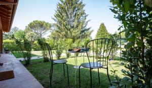 2 sillas y una mesa en un jardín en G&B suite, en Castelnuovo di Porto