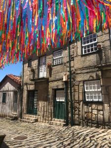 a stone building with colorful flags hanging from it at Casa da Muralha Cerveira in Vila Nova de Cerveira