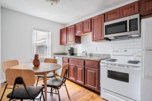 a kitchen with wooden cabinets and a table with chairs at South Boston 2br w building wd nr seaport BOS-912 in Boston