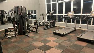 a gym with several treadmills and machines in a room at PINTARMAN SERVICE APRTMENT @ THE STIRLING SUITES in Miri