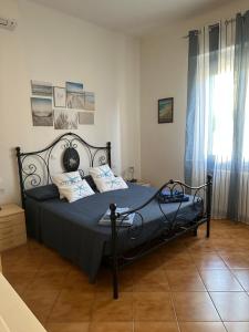 um quarto com uma cama preta com lençóis e almofadas azuis em Casa Batty em Cattolica