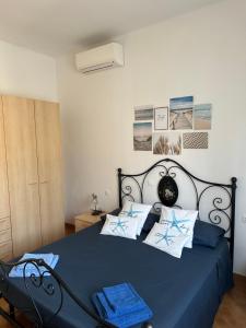 a bedroom with a blue bed with blue and white pillows at Casa Batty in Cattolica