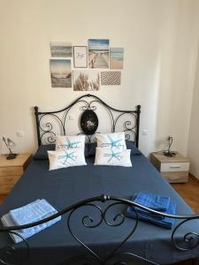 a bedroom with a black bed with blue sheets and pillows at Casa Batty in Cattolica