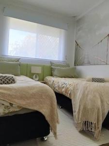 a bedroom with two beds and a window at Simply delightful unit close to CBD and Beach in Perth