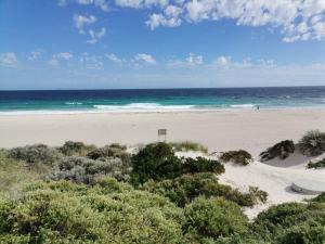 a sandy beach with the ocean in the background at Modern Unit Near CBD & Beach, Free Parking in Perth