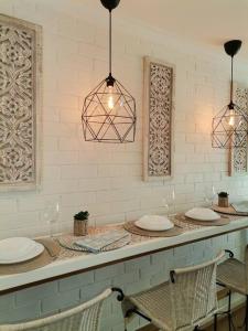 un comptoir avec deux chaises, des assiettes et des lumières dans l'établissement Delightful Unit Near CBD & Beach, Free Parking, à Perth