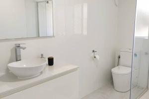 a white bathroom with a sink and a toilet at Modern Unit Near CBD & Beach, Free Parking in Perth +24 photos