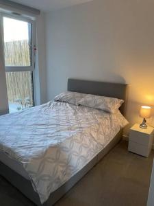 a bed in a white room with a window at Flat in the Heart of Chelmsford in Chelmsford