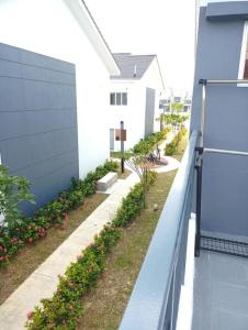 um quintal lateral de uma casa com uma cerca e flores em Izz Homestay 6Pax Near UITM Puncak Alam em Bandar Puncak Alam
