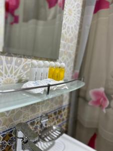 een badkamer met een glazen plank naast een wastafel bij Abuzar in Bukhara