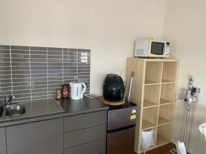 a kitchen with a counter top with a microwave at Self contained guest house - sleeps 4 in Gold Coast