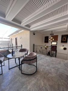 een kamer met een tafel en stoelen op een balkon bij Abuzar in Bukhara