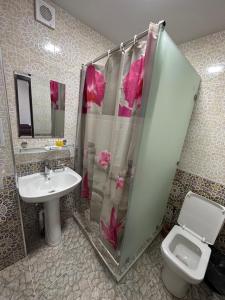 een badkamer met een douche, een toilet en een wastafel bij Abuzar in Bukhara