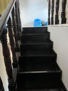 a stairway with black steps and a blue bag at Chalé meu príncipe in Marapanim