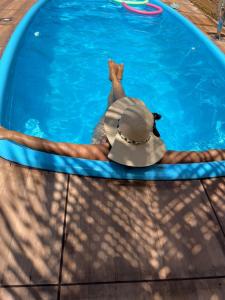 Ein Hund, der einen Hut im Pool trägt. in der Unterkunft Chalé meu príncipe in Marapanim