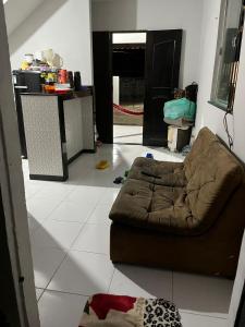ein Wohnzimmer mit einem braunen Sofa auf einem weißen Boden in der Unterkunft Chalé meu príncipe in Marapanim