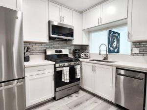 a kitchen with white cabinets and a stove top oven at Stylish SD Living (10 min drive to Downtown and 15 min to beach) in Chula Vista
