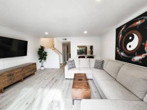 a living room with a couch and a flat screen tv at Stylish SD Living (10 min drive to Downtown and 15 min to beach) in Chula Vista