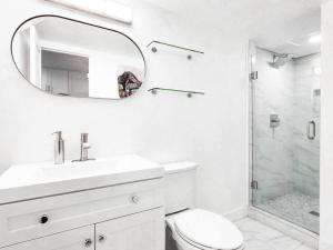 a white bathroom with a sink and a mirror at Stylish SD Living (10 min drive to Downtown and 15 min to beach) in Chula Vista