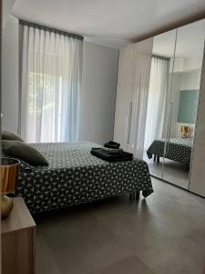 sypialnia z łóżkiem i dużym lustrem w obiekcie "La Terrazza di Via Roma" Delta del Po - Private Parking w mieście Porto Viro