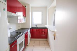 una cocina con armarios rojos y una ventana en Lovely appt between Paris&Disney, en Noisy-le-Grand