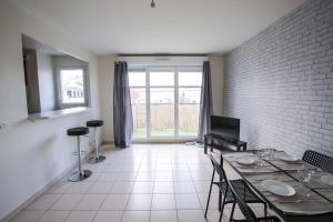 a dining room with a table and a brick wall at Lovely appt between Paris&Disney in Noisy-le-Grand