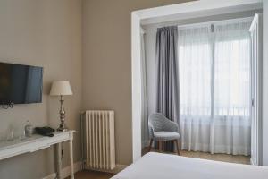 a hotel room with a bed and a window at Mesón Castilla Atiram Hotels in Barcelona