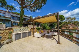 eine Terrasse mit einem Sofa und einem Pavillon in der Unterkunft Villa Mitjorn Cala Canyelles in Lloret de Mar